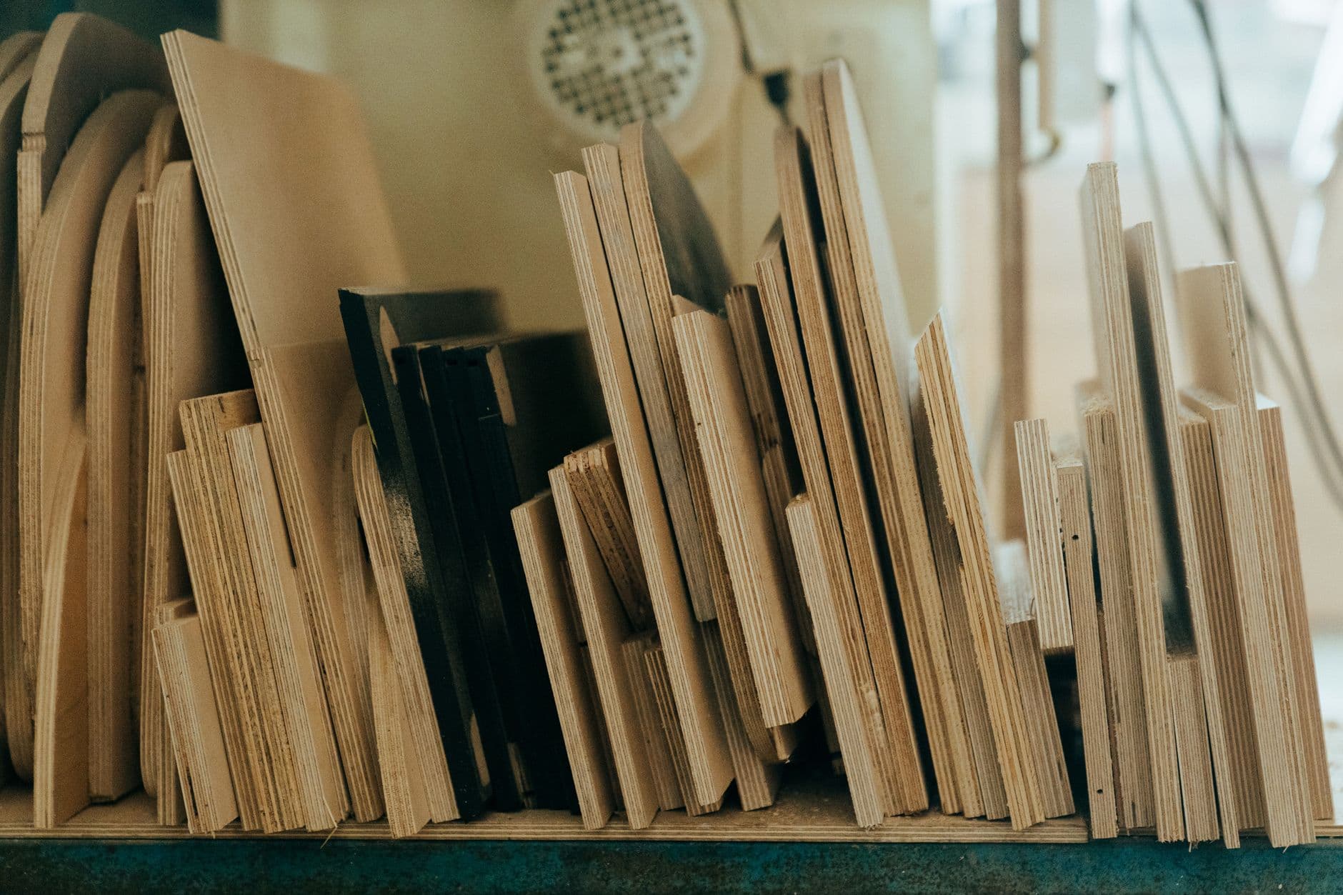 Plywood offcuts standing on edge in a workshop, layered plies visible along the cut edges