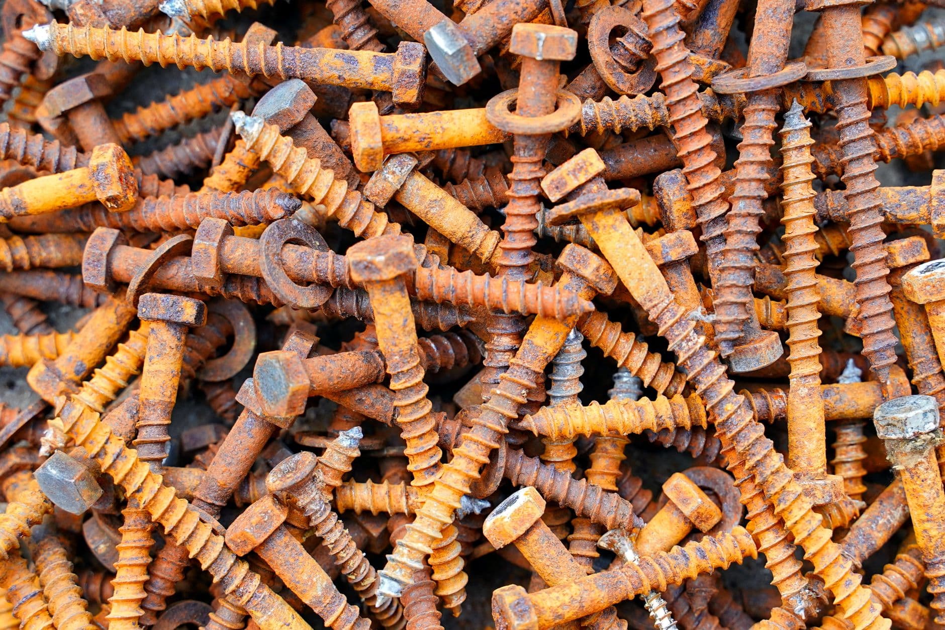 A heap of rusty hex-head lag bolts and washers